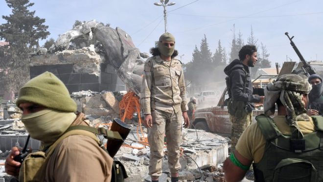 Поддерживаемые Турцией сирийские повстанцы собираются возле разрушенной статуи Кава в городе Африн на севере Сирии 18 марта 2018 года