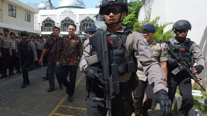 Губернатор Пурнама (третий слева, в рубашке в виде батика) сопровождается антитеррористической полицией из суда Северной Джакарты в Джакарте 20 декабря 2016 года.