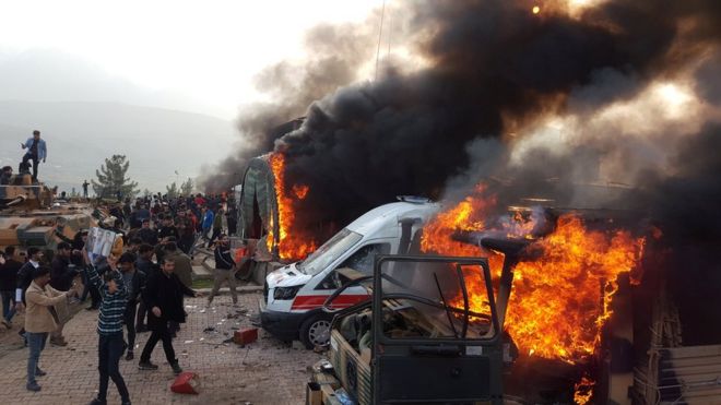 Дым поднимается из транспортных средств после того, как протестующие ворвались в турецкий военный лагерь возле Дохука, Ирак