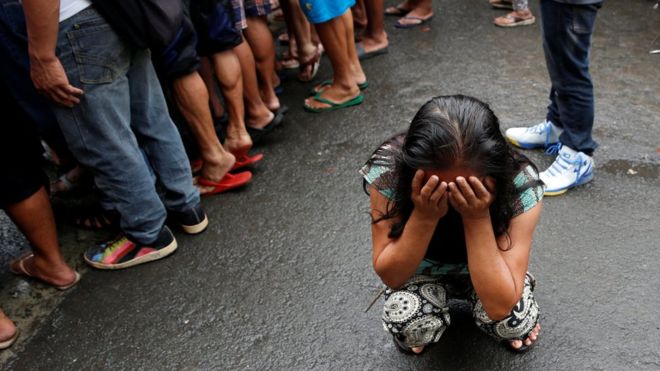 Подруга семьи плачет после того, как 47-летняя Нора Асиело была застрелена неизвестными мужчинами, когда провожала своих двоих детей в школу в Маниле, Филиппины 8 декабря 2016 г.