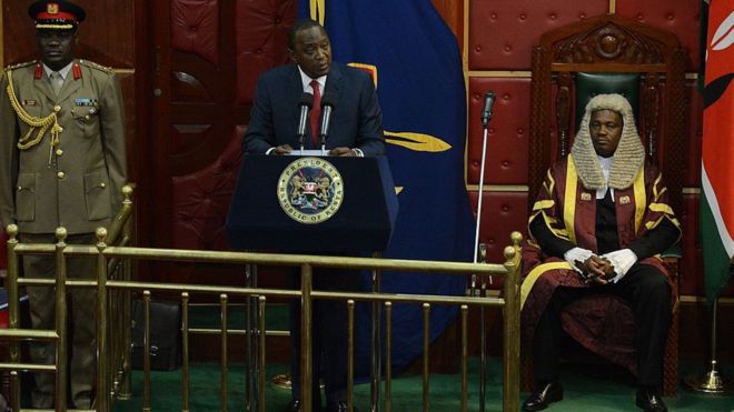Президент Ухуру Кеньятта (С) в окружении спикера Национального собрания Джастина Мутури (справа) выступает перед парламентом 26 марта 2015 года в Найроби