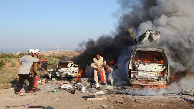 Rescue workers trying to extinguish a fire after an air strike on a van west of the town of Suran (1 September 2016)