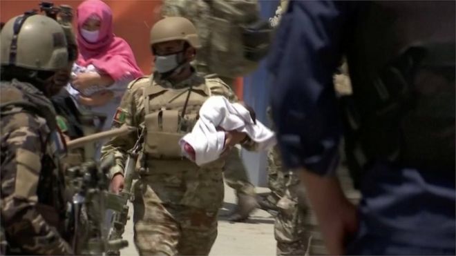 Afghan security personnel evacuate a baby from the hospital