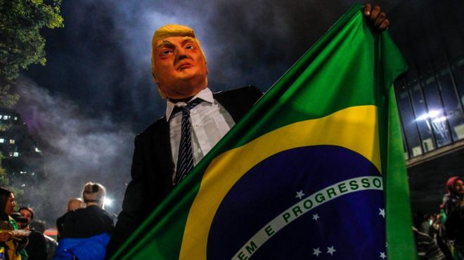 Сторонник господина Болсонаро носит маску президента США Дональда Трампа