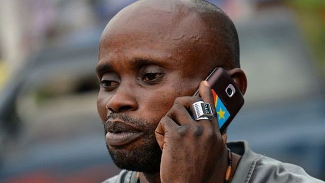 Местный житель использует мобильный телефон в Киншасе 4 февраля 2015 года