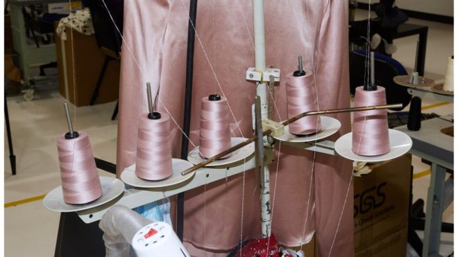 Розовая швейная нить на машинке