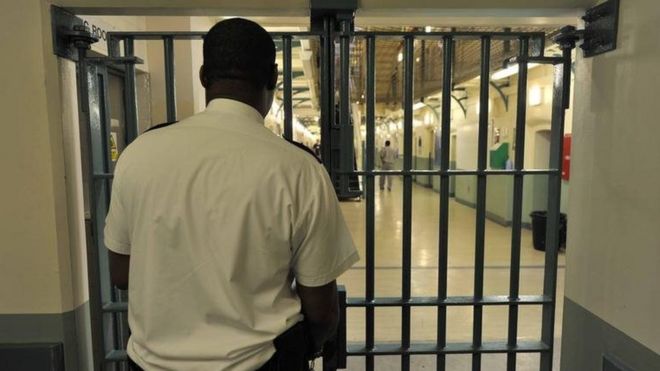 Тюремный служащий запирает дверь в полыни полыни