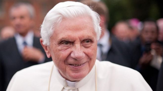 El papa emérito Benedicto XVI sonríe a un grupo en 2020