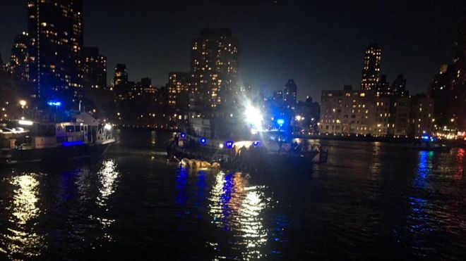 A dark and blurry photo of a small ship on the New York East River