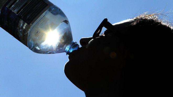 человек пьет воду на солнце