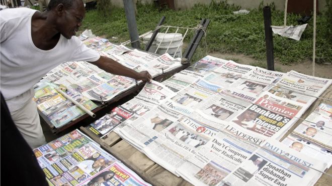 Мужчина выбирает газету с заголовками о выходе Нигерии из всех событий ФИФА на газетный киоск в Лагосе - 1 июля 2010 года