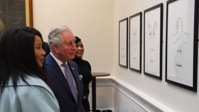 Принц Чарльз и Маказиве Мандела смотрят на рисунки Нельсона Манделы, выставленные в Сент-Джорджес-Холле в Ливерпуле