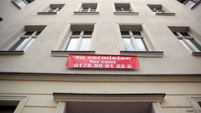 На блоке жилых квартир стоит знак недвижимости, рекламирующий квартиру в Берлине (апрель 2013 г.)