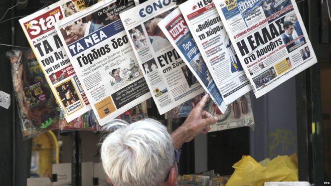 Мужчина проверяет утренние газеты в Афинах