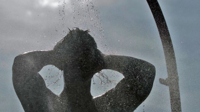 A file photo of a male figure in silhouette taking a shower outdoors