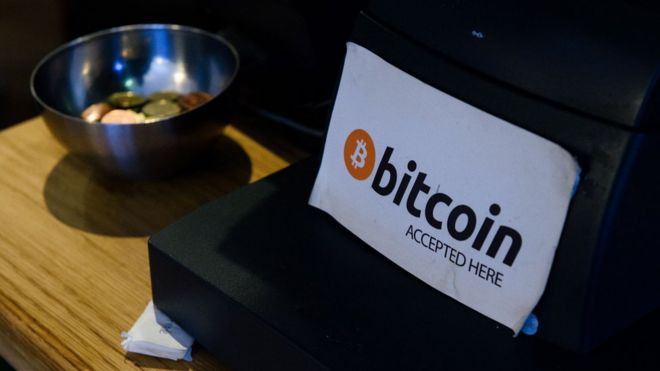 Bir kafede kasanın yanında "Bitcoin kabul edilir" yazısı.