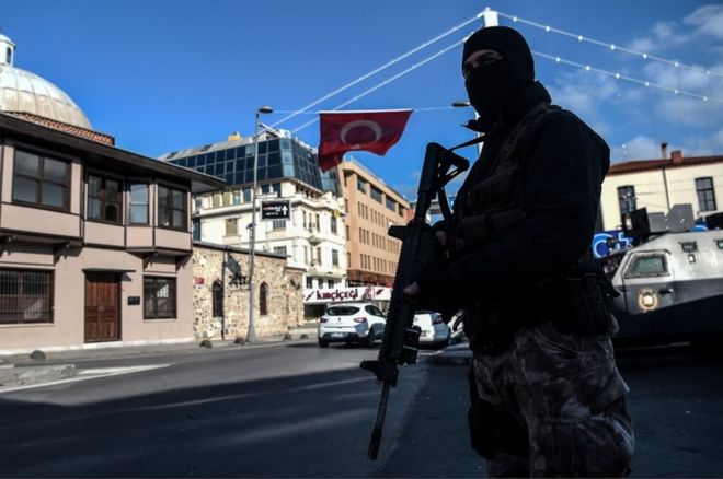 Офицер полиции специального назначения Турции стоит на страже в районе Ортакой, рядом с ночным клубом Рейна, 2 января 2017 года в Стамбуле, на следующий день после новогоднего обстрела.