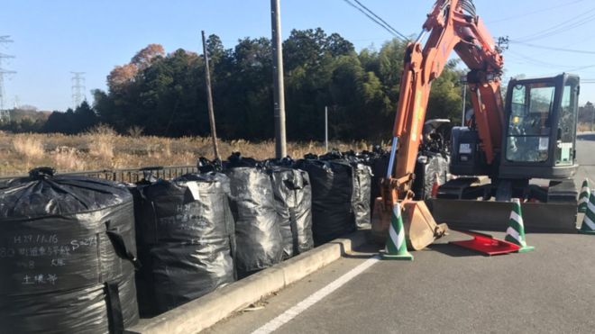 Мешки с почвой, которые могли быть загрязнены, находятся на пустой улице в префектуре Фукусима.