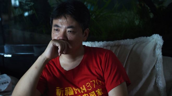 Цзян Хуэй, чья мать была на рейсе MH370, смотрит телевизионный информационный бюллетень о самолете в своем пекинском доме в 2015 году