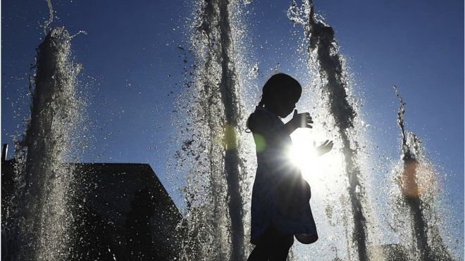 Child in fountain on warm summer's day in Moscow