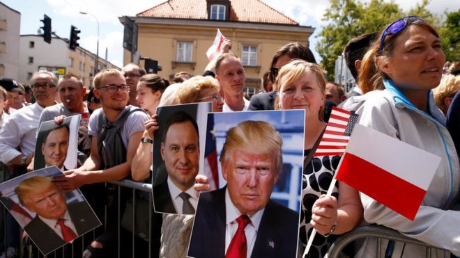 Люди с портретами президента США Дональда Трампа и президента Польши Анджея Дуды ждут на площади Красинских в Варшаве, 6 июля