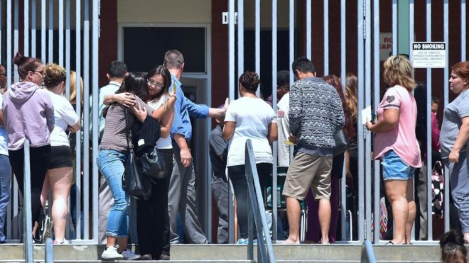 Padres esperan a sus hijos en la escuela Cajon