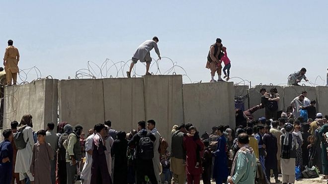 Афганцы пытаются перелезть через забор в аэропорту Кабула