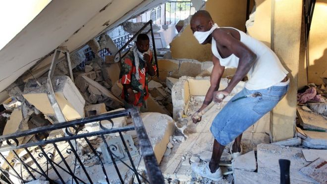 Hombre retira escombros en busca de supervivientes tras el terremoto de Haití en 2010.