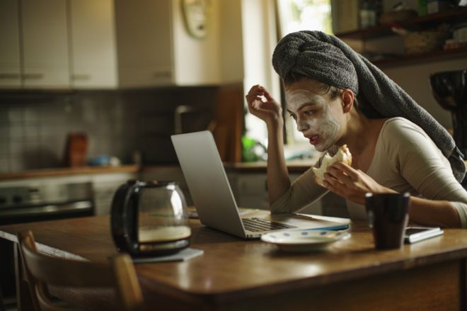 Женщина за кухонным столом на компьютере