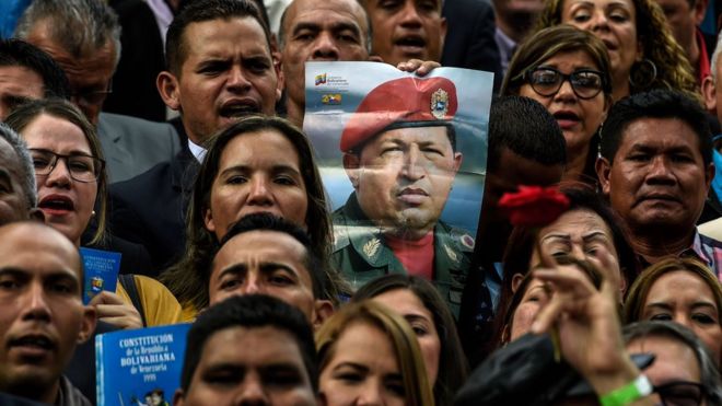 Los nuevos legisladores sostienen un cartel con el retrato de Chávez.