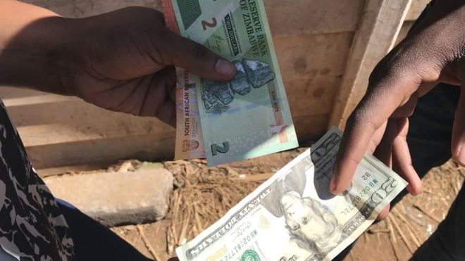 A money changer doing a deal with US dollars and Zimbabwean bond notes