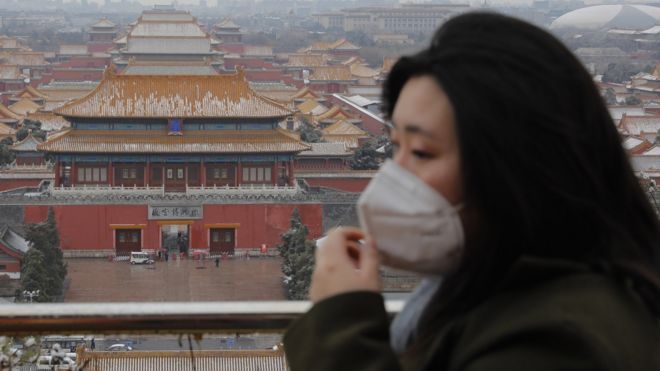 A woman wears a protective mask at Jingshan Park in Beijing, China, 14 February 2020.