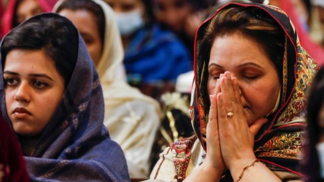 پاکستان میں ایک کرسمس کے موقع پر خاتون کورونا کی وبا کے دوران دعا کر رہی ہیں (فائل فوٹو)
