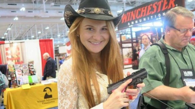 Мария Бутина в ковбойской шляпе держит пистолет на оружейном съезде