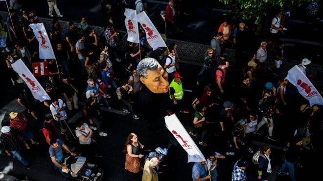 Протестующие держат марионетку премьер-министра Португалии Антонио Косты во время митинга в Лиссабоне