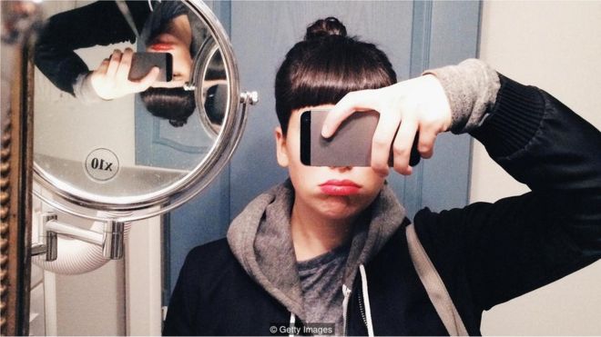 Девојка која прави селфи испред огледала