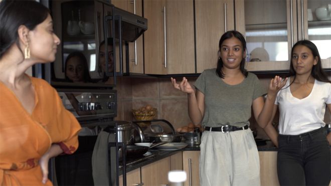 Ithra and two of her sisters in the kitchen