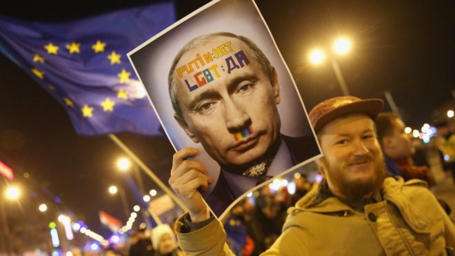 Демонстранты, в том числе один с портретом президента России Владимира Путина и другой, размахивающий флагом Европейского союза, маршируют в знак протеста против визита Путина в Будапешт, а также против правительства премьер-министра Венгрии Виктора Орбана в феврале 2015 года в Будапеште, Венгрия