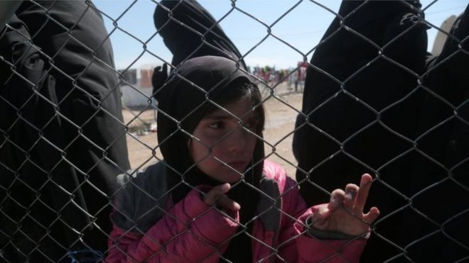 8 марта 2019 года девушка просматривает забор, связанный цепью, в лагере для перемещенных лиц аль-Хол в мухафазе Хасака, Сирия.