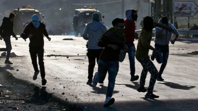 Палестинские демонстранты бросают камни в израильские силы безопасности во время столкновений в городе Наблус на Западном берегу