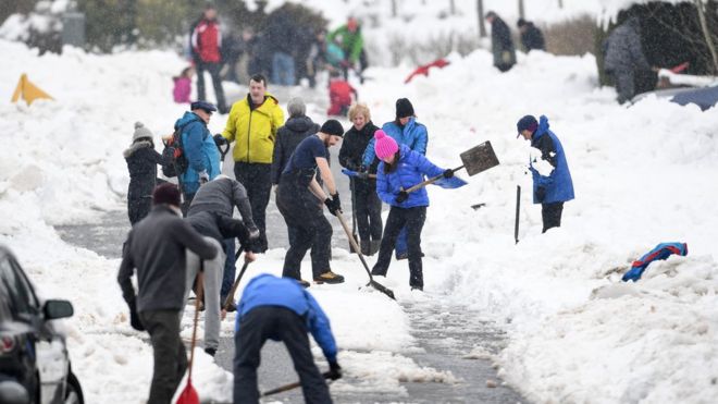 Представители общественности очищают заснеженную улицу 4 марта 2018 года в Бланфилде, Шотландия