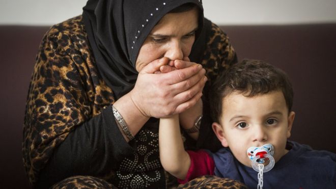 Сирийский беженец Сосан аль-Джасем целует своего сына Фадля в их временном доме в Пиктоне, Онтарио, Канада,