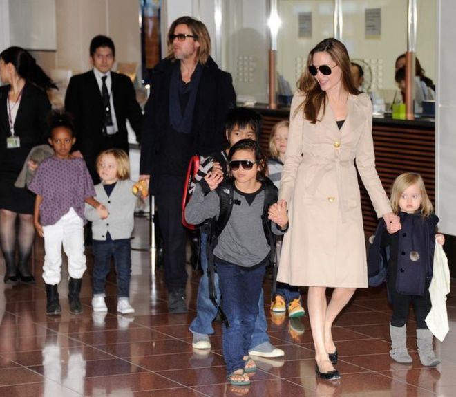 Снятые со своими детьми американские кинозвезды Брэд Питт и Анджелина Джоли прибывают в аэропорт Ханэда в Токио 8 ноября 2011 года.