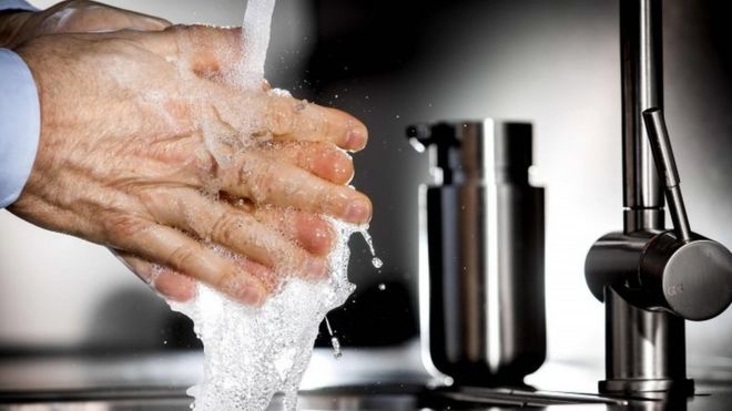 हाथ धोते हुए एक व्यक्ति