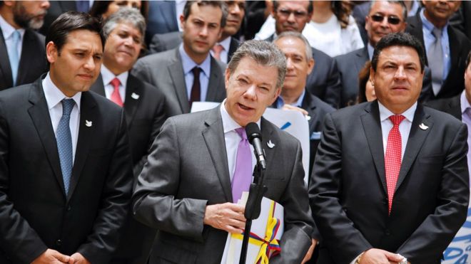Президент Колумбии Сантос (с) держит копию с окончательным текстом мирного соглашения с Фарком