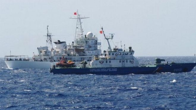 This picture taken on 14 May shows a Chinese coast guard ship (back) sailing next to a Vietnamese coast guard vessel (front) near China's oil drilling rig in disputed waters in the South China Sea.