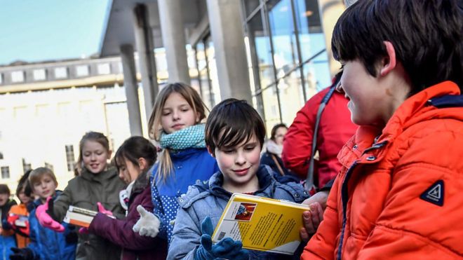 Niños trasladando libros en una cadena humana en la ciudad de Gante