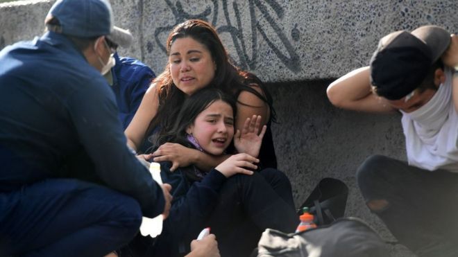 Una mujer abraza a una niña durante las protestas en Chile.
