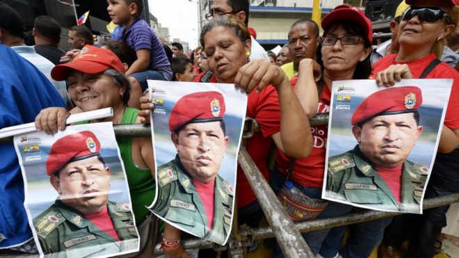 Сторонники президента Николаса Мадуро держат плакаты бывшего президента Уго Чавеса во время демонстрации в Каракасе 3 августа 2013 года.