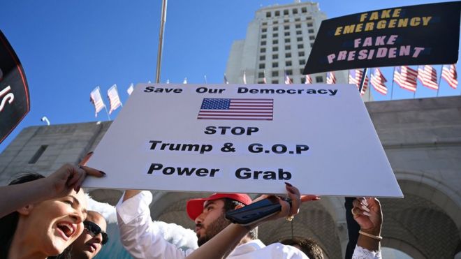 People protest against Donald Trump's National Emergency declaration, February 18, 2019, outside City Hall in Los Angeles